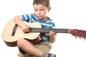 Ear Training For The Guitar - A young boy playing the guitar.