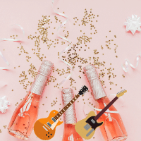 Two guitars in front of three bottles of champagne.