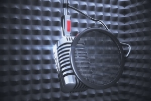 Learning Guitar Solos - An image of a microphone and a noise screen in a recording studio
