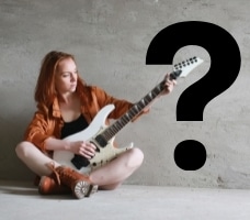 Learning Guitar Solos - A girl playing an electric guitar that is surrounded by a question mark