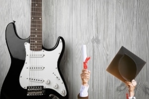 Learning Guitar Solos - An image of a guitar, a diploma, and a graduation cap