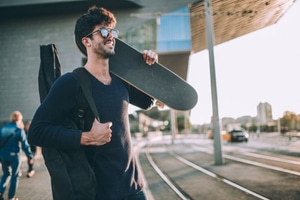 Cheap Guitar Gig Bags - Someone carrying a gig bag and a skateboard at the same time