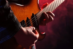 Learn To Play A Guitar Fast – Someone playing a chord on an electric guitar