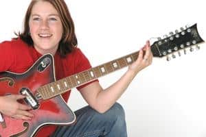 Guitar String Gauge Guide – A young woman playing an electric guitar