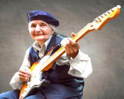 Learning Guitar For Seniors - An older woman playing a Stratocaster guitar.