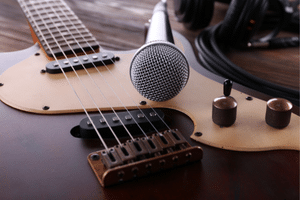 Learning Guitar For Seniors - A microphone laying on top of an electric guitar