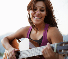 Guitar Tips For Beginners - A woman having fun playing the guitar.