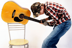 Relax When Playing Guitar – A young man attempting to smash his guitar on a chair