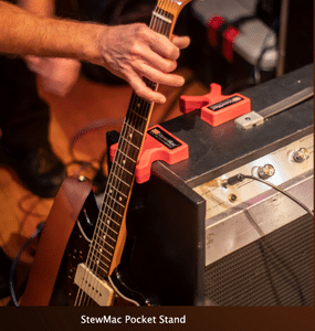 How To Store A Guitar – A musician places his guitar neck in an amp pocket stand to keep it safe.