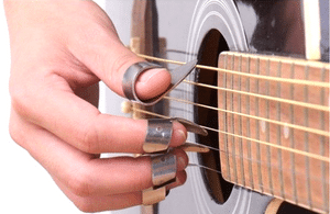 Playing Guitar With Arthritis - A photo of someone playing the guitar using thumb and finger picks.
