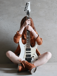 TUSQ XL Nut - A girl holding an electric guitar.