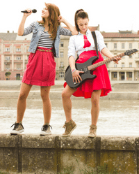 Wireless Guitar System - Two girls with a wireless guitar and microphone.