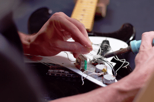 How To Set Up An Electric Guitar - Soldering a ground wire to the volume control.
