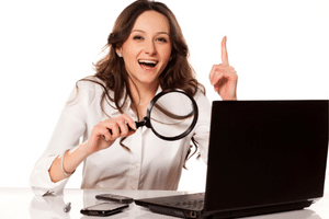 Online Guitar Shopping - A woman having a "eureka" moment while searching on a laptop.