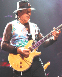 Why Is My Guitar Tone So Bad - A photo of Carlos Santana playing his guitar onstage.