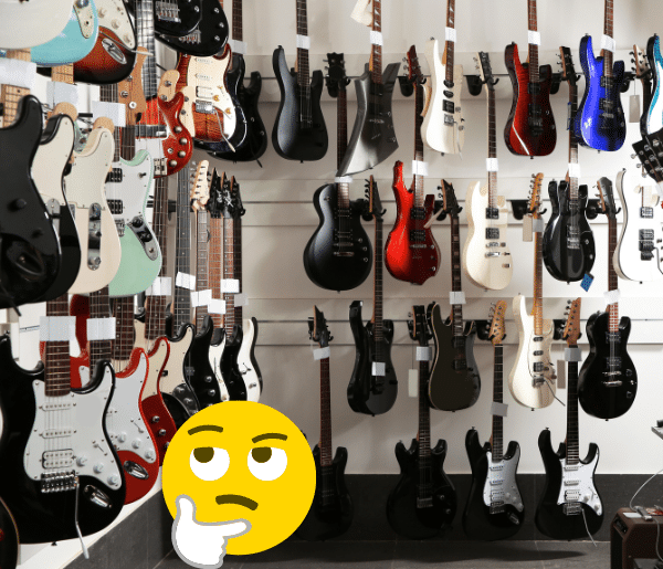 Are Cheap Electric Guitars Harder To Play - A wondering face in a room of electric guitars.